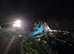 Três pessoas ficam feridas após caminhão bater na traseira de carro e capotar em rodovia 